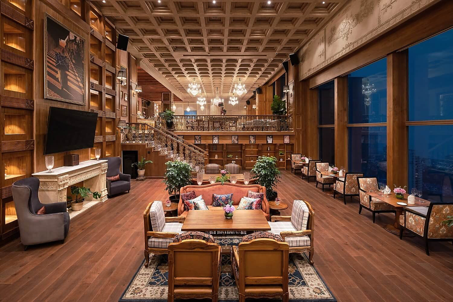 The 38 Manhattan penthouse hall at dusk, chandeliers lit above the long room
